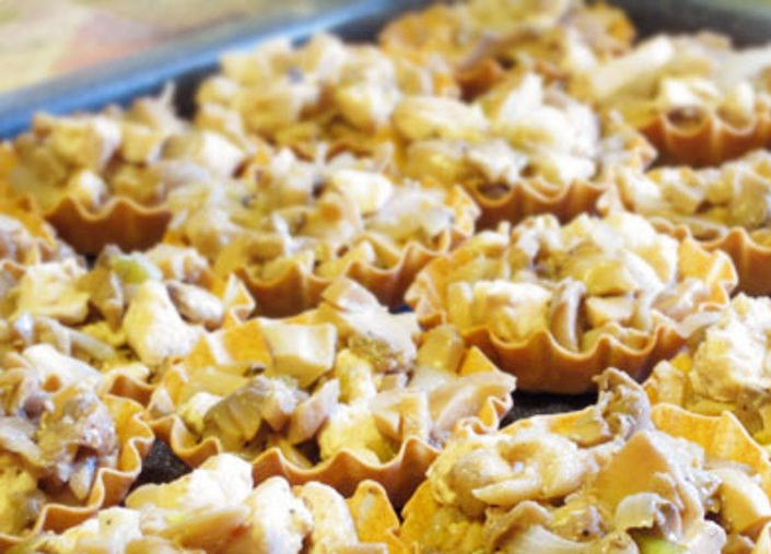 1. Этап. Тарталетки с курицей и грибами: На противне расставьте готовые тарталетки и выложите в каждую начинку с горкой.