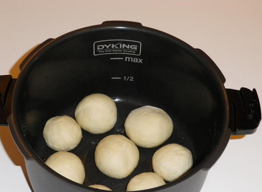 1. Этап. Пампушки в мультиварке: Тесто положите в теплое место на полчаса, чтоб оно подошло. Затем обомните его руками и скатайте небольшие шарики. Поместите их в смазанную маслом чашу мультиварки так, чтобы между шариками оставалось пространство. В процессе приготовления пампушки увеличатся, а это пространство заполнится.