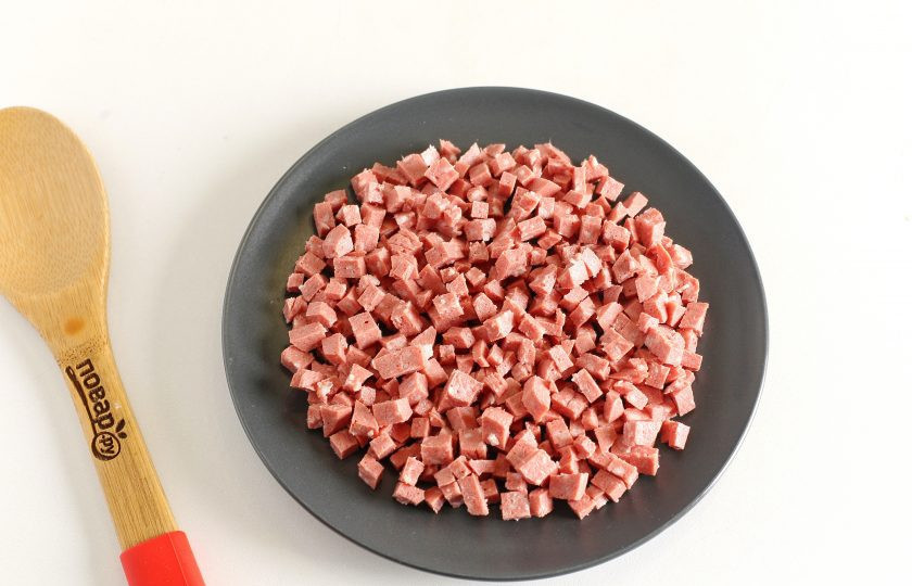 1. Этап. Салат с копчёной колбасой: Салат выкладывается слоями. Первым слоем выложите нарезанную небольшими кубиками копченую колбасу.