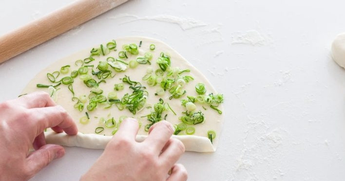 1. Этап. Жареные лепешки с зеленым луком: 6. Скрутите лепешку в тонкую трубочку. Следите, чтобы не вывалился лук.