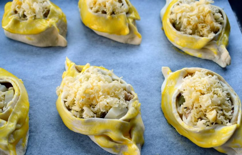 1. Этап. Лодочки из слоеного теста: 6. Смажьте заготовки пирожков слегка взбитым желтком. Разместите их на противне с пергаментом для выпечки. Поставьте запекаться в разогретую до 180 градусов духовку на 30-35 минут, до румяной корочки.