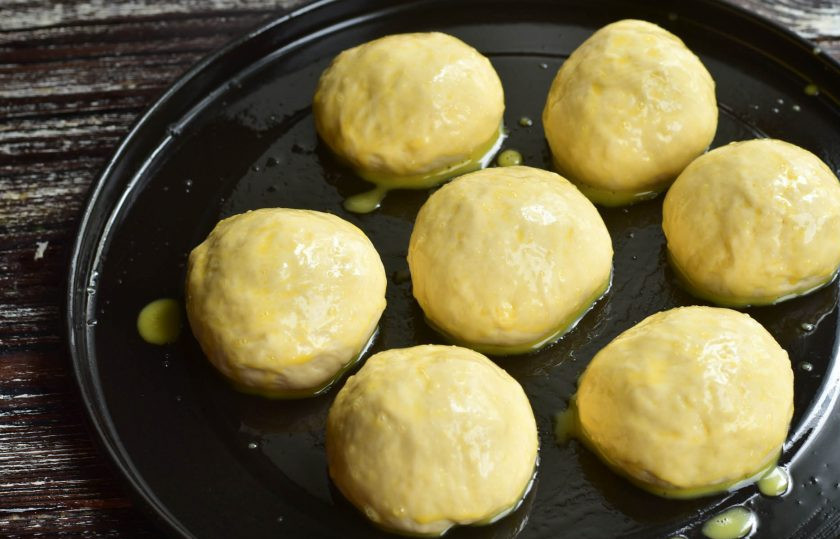 1. Этап. Пампушки с сыром: Сформируйте пампушки. Противень смажьте растительным маслом, выложите пампушки на некотором расстоянии друг от друга. Смажьте их яичным желтком.