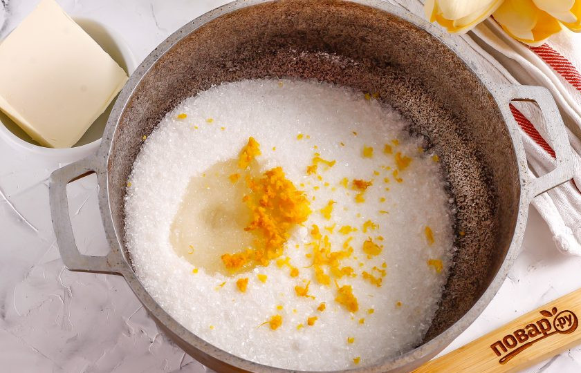 1. Этап. Лимонная карамель: Сахар всыпьте в казан или ковш с антипригарным дном. Ошпарьте лимон кипятком и с половины фрукта натрите цедру в емкость с сахаром. Выдавите из этой же половины лимона сок и влейте в емкость.