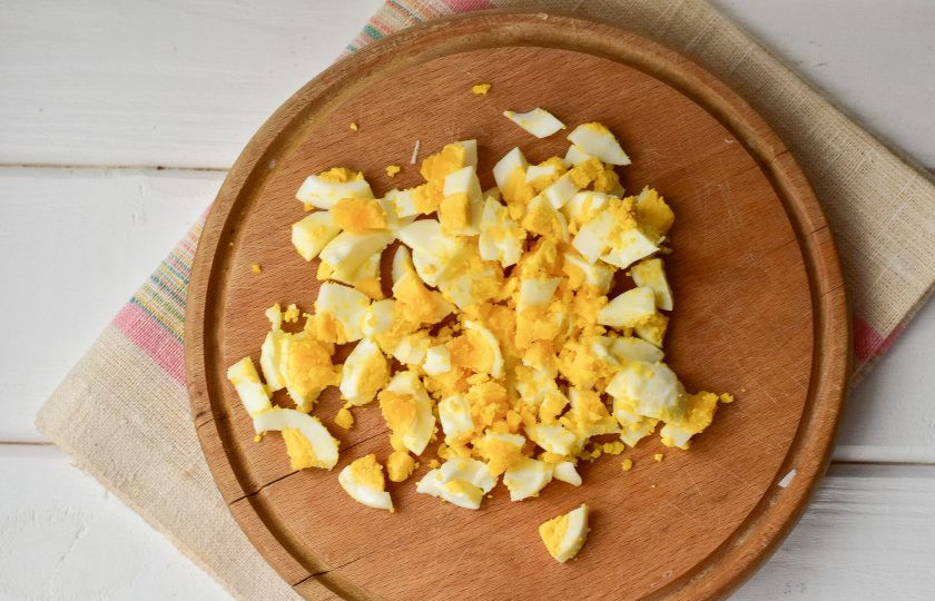 1. Этап. Салат Марсель с крабовыми палочками: Куриные вареные яйца очистите и нарежьте.