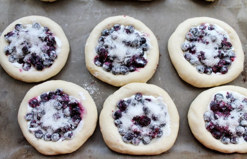 1. Этап. Ватрушки с черникой: Разложите чернику по ватрушкам и посыпьте сахаром. Накройте и дайте подойти в течение 15-20 минут в теплом месте.