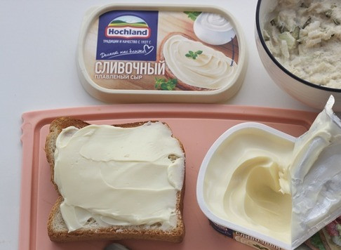 1. Этап. Рыбный паштет: Намажьте сливочный сыр Hochland на хлеб.