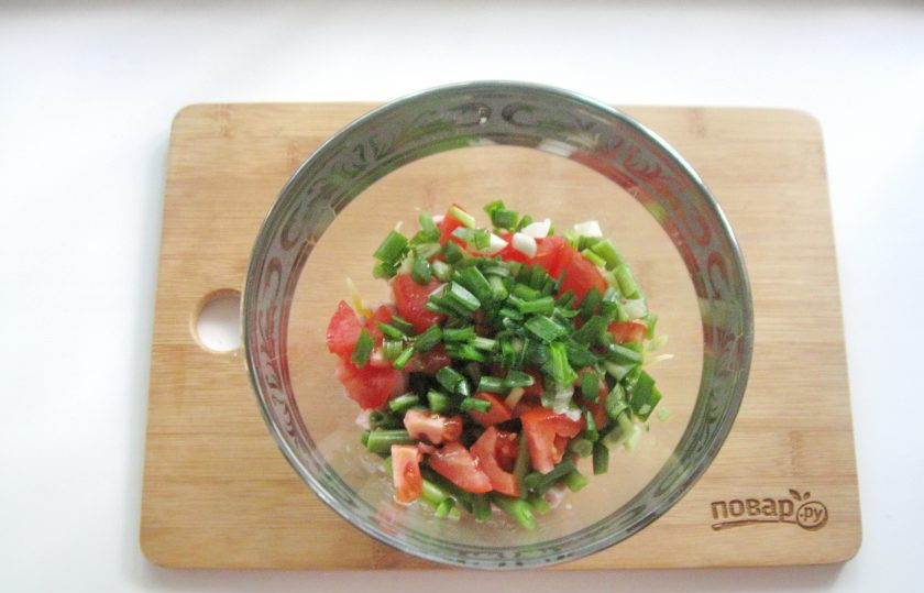 1. Этап. Салат из спаржевой фасоли с ветчиной: Помидор нарежьте кубиками, зеленый лук — мелко и выложите в салат.