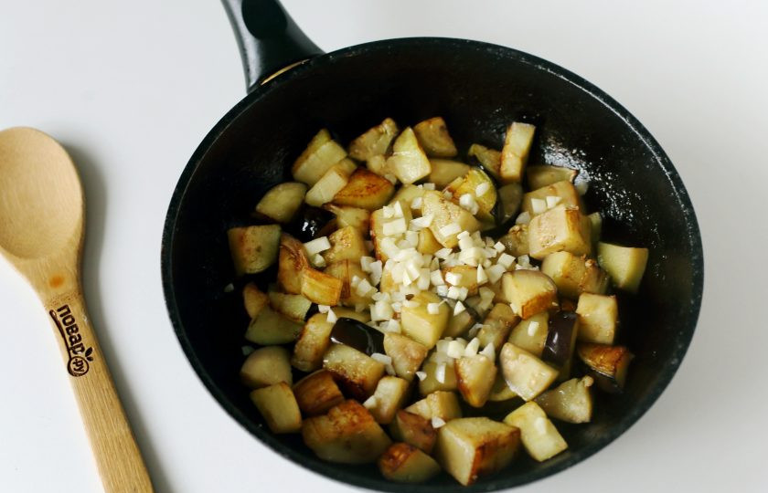 1. Этап. Тушеные баклажаны с чесноком: Баклажаны посолите и обжарьте на среднем огне периодически помешивая до полной готовности. Затем добавьте измельченный чеснок и готовьте все вместе еще около 2-3 минут.