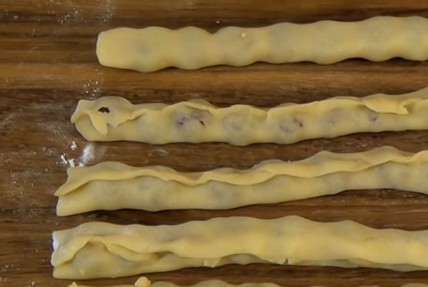 1. Этап. Торт Медовые соты: 4. На каждую полосу посередине выложите консервированные вишни, отжатые от сока. Защепите края каждой полосы. В разъемную форму диаметром 24 см, застеленную бумагой для выпечки и смазанную сливочным маслом, выложите полоски теста с форме спирали, двигаясь от края к центру.