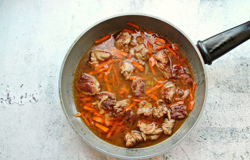 1. Этап. Плов с уткой и черносливом: Влейте в сковороду половину горячей воды, посолите и тушите все на медленном огне в течение 15 минут.