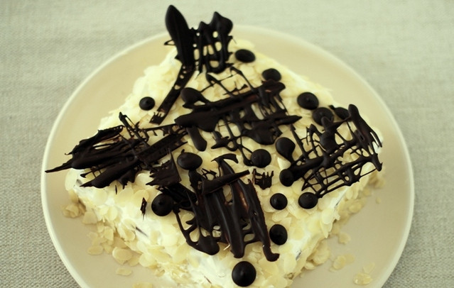 1. Этап. Творожный торт из печенья: На пергамент нанесите растопленный шоколад в виде узоров, дайте им застыть в холодильнике. А потом ими можете украсить готовый творожный торт из печенья.