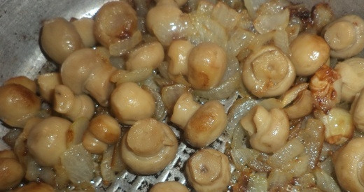 1. Этап. Салат Курица с шампиньонами: Лук мелко нашинкуйте. Обжарьте его в масле до прозрачности, затем добавьте в сковороду мелкие шампиньоны, предварительно промыв их. Готовьте всё вместе около 5 минут.