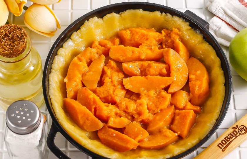 1. Этап. Песочный пирог с вареньем и яблоками: Спустя указанное время распределите тесто по форме. Форму смазывать не нужно, так как в тесте уже содержится жир. Выложите на тесто варенье.