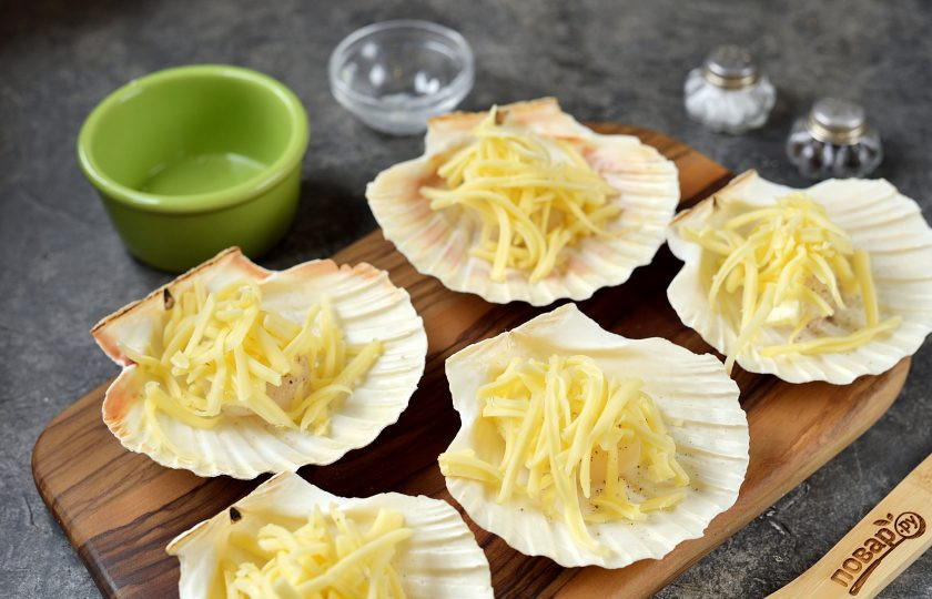 1. Этап. Гребешки в раковинах под сыром: И присыпьте каждый гребешок натертым твердым сыром.