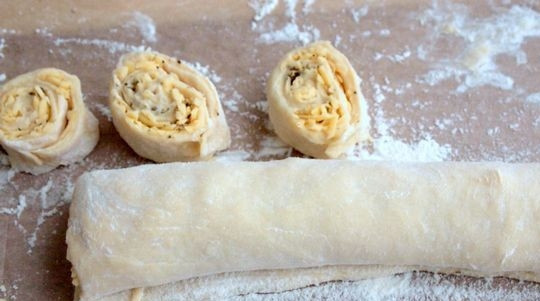 1. Этап. Оригинальные булочки: Заверните тесто в рулет. Нарежьте его на кусочки. Оставьте изделия на 20 минут в форме для выпечки.