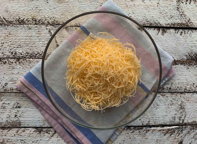 1. Этап. Салат Избушка из крабовых палочек: Сыр натрите на мелкой терке.