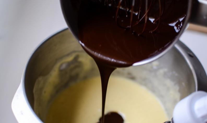 1. Этап. Французский шоколадный торт: Добавьте растопленную шоколадную массу. Перемешайте до однородности.