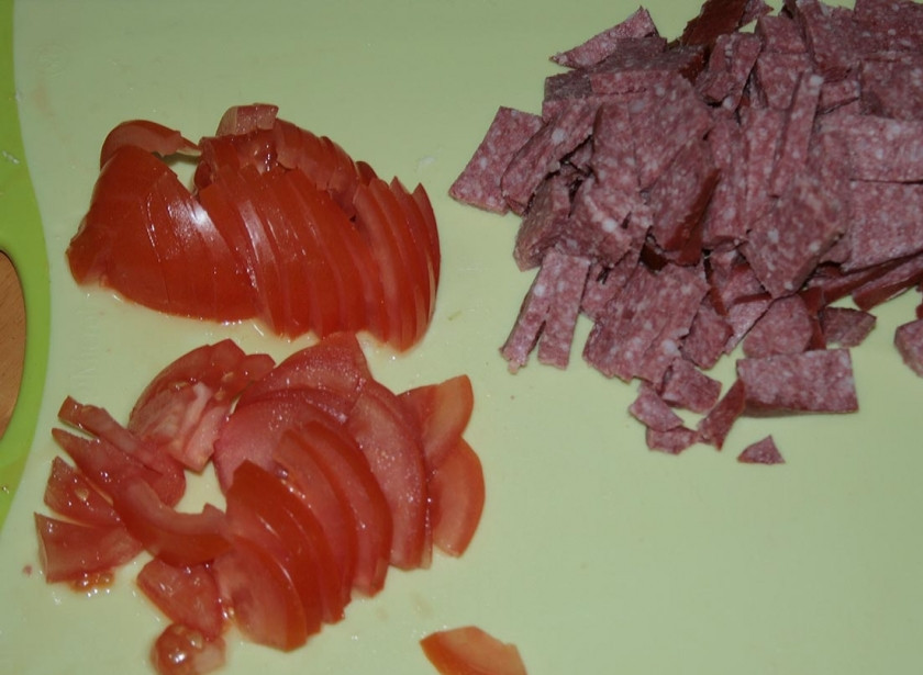 1. Этап. Салат пикантный с колбасой: Тем временем порежьте помидор и колбасу.