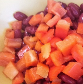 1. Этап. Крабовые палочки с фасолью: В салатницу выложить фасоль, а также нарезанные мелкими ломтиками помидоры и перец.