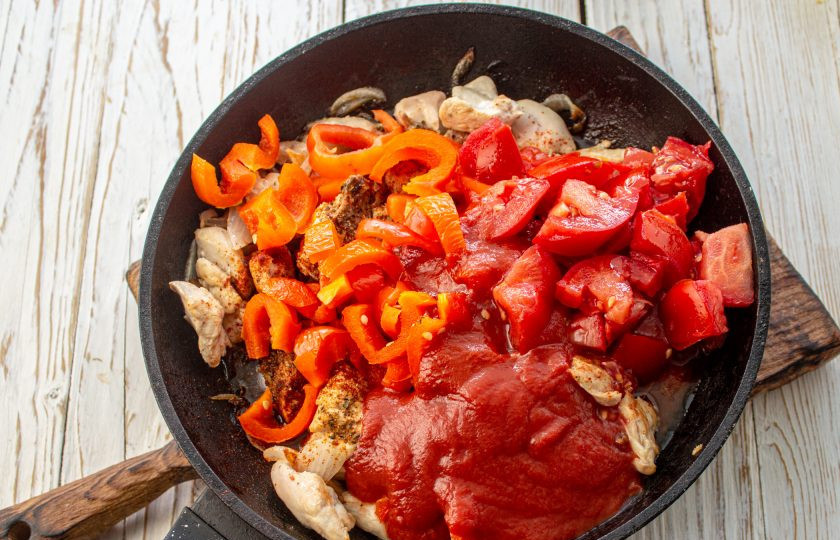 1. Этап. Лобио с курицей и красной фасолью: Помидоры нарежьте на кусочки, добавьте в сковороду к курице, туда же отправьте нарезанный сладкий перец и томатный соус. Влейте 100-150 мл. воды, доведите до кипения, посолите по вкусу и добавьте сахар. Тушите 5-7 минут.