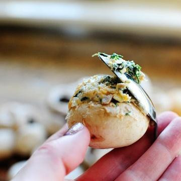 1. Этап. Запеченные грибы, фаршированные сыром и шпинатом: 7. Используя ложку, заполнить приготовленной начинкой шляпки грибов.