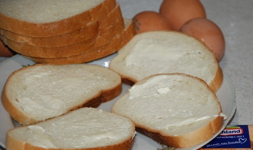 1. Этап. Горячий бутерброд По-деревенски: 4 ломтика батона нужно намазать тоненьким слоем сливочного масла. Фарш смешать слегка обжарить на сковороде. Разогрейте духовку на 200 градусов. Помидор нарежьте слайсами.