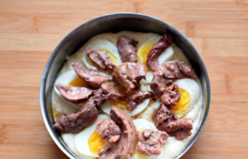 1. Этап. Пирог с печенью трески: Часть теста вылейте в смазанную форму. Сверху разложите ломтики вареный яиц (лучше, если они будут сварены в мешочек), кусочки печени трески без масла. Поперчите начинку.