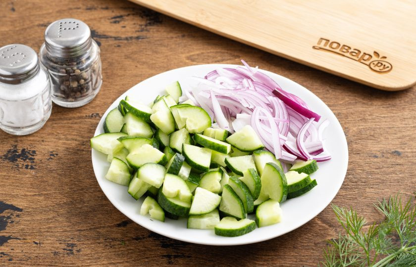 1. Этап. Салат по-грузински из огурцов и зелени: Огурцы нарежьте четвертинками, а красный лук перьями.