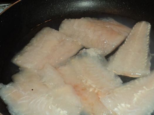 1. Этап. Рыба отварная с соусом польским: Теперь приступим к варке рыбы. Можно просто сварить в кастрюле в воде, а рыбный бульон использовать для ухи. А можно сделать так, чтобы все полезные вещества остались в рыбе. Для этого сварим рыбу в небольшом количестве воды в сковороде. Наливаем в сковороду пол стакана воды, чуть-чуть солим и выкладываем в нее рыбное филе.