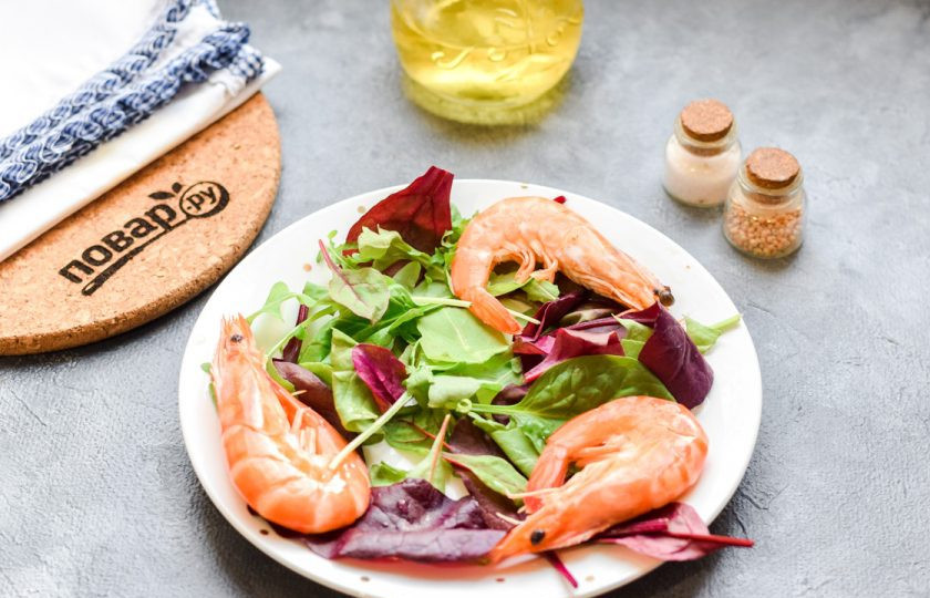 1. Этап. Салат с красной икрой: Креветки можете отварить, можете просто поджарить. Я покупаю охлажденные креветки, они предварительно уже отварены. Часть креветок добавим в салат неочищенными, часть очистим. Итак, выложите 3-4 штуки креветок в салат.