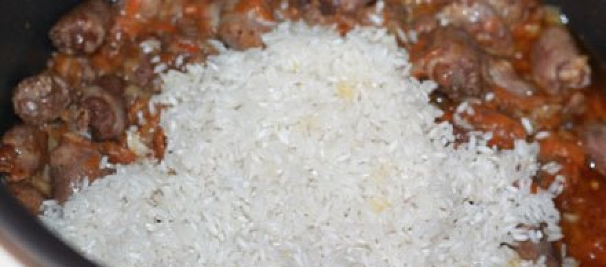 1. Этап. Плов с сердечками в мультиварке: Засыпаем промытый рис, солим, кладем специи по вкусу и лавровый лист.