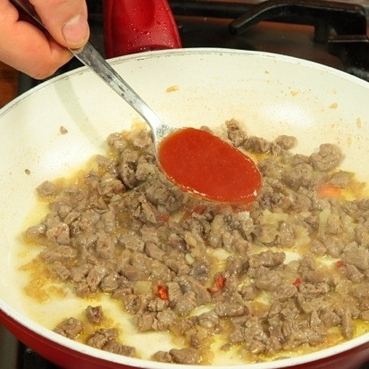 1. Этап. Лук-порей с мясом: Когда мясо слегка обжарится, покроется корочкой и потемнеет, добавляем в сковороду бульон, томатную пасту и специи. Если нет бульона, можно просто добавить немного воды. Доводим соус до кипения.