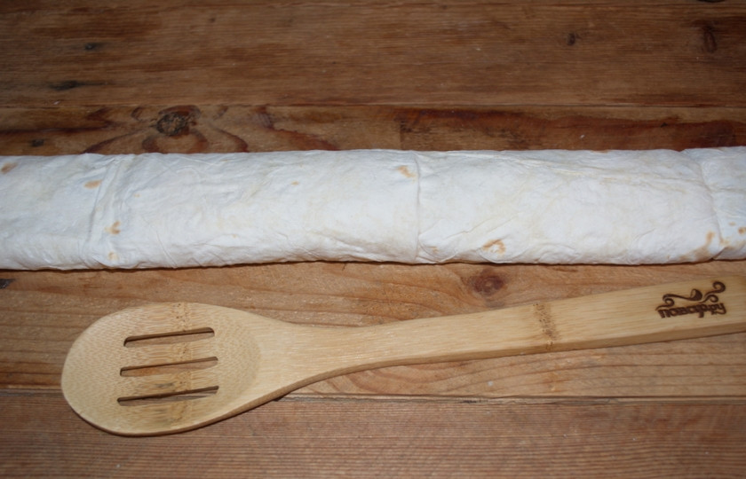 1. Этап. Лаваш с курицей и яйцом: Сверните лаваш в рулетик. Сверху слегка придавите, чтобы все составляющие крепко схватились и не высыпались.