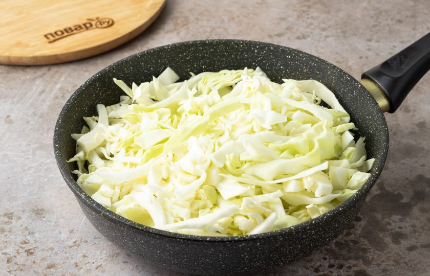 1. Этап. Капуста со сливками: Выложите в сковороду капусту. Жарьте на среднем огне около 7 минут.