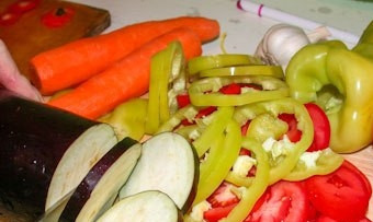 1. Этап. Баклажаны в казане слоями: Все овощи промойте и нарежьте кольцами, а чеснок измельчите.