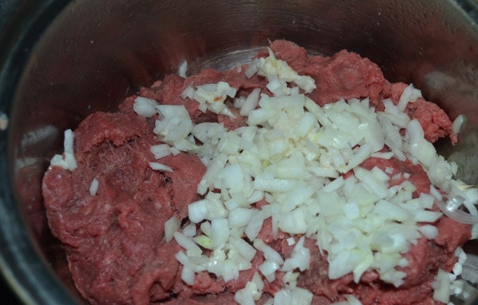 1. Этап. Паровые котлеты из говядины: Добавить измельченные лук и чеснок.