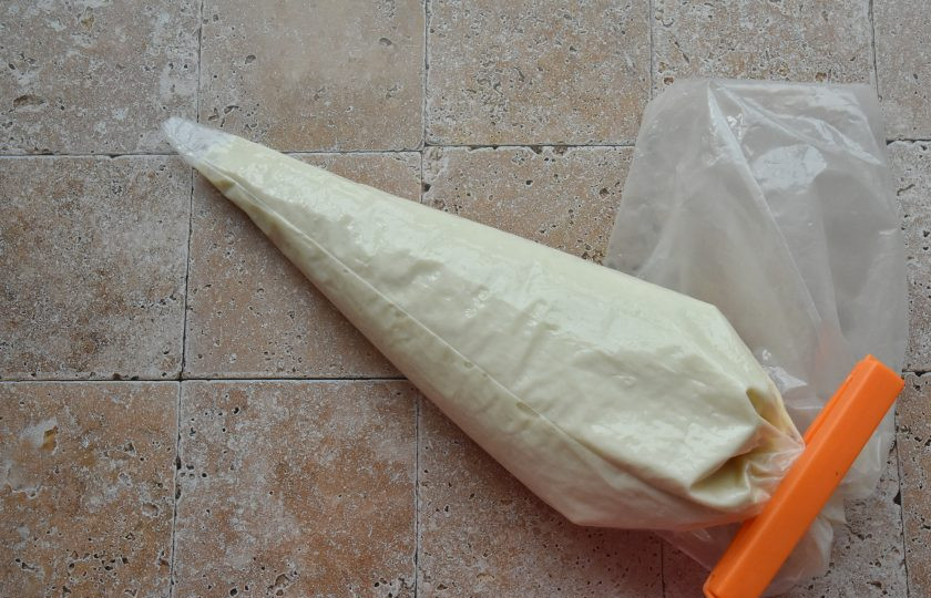 1. Этап. Дутые оладьи: Оладьевое тесто в сковороду можно выложить через кулинарный рукав. Таким образом вы получите одинакового размера ровные оладьи. Для этого, после замеса выложите тесто в кулинарный мешок. Когда мешок будет заполнен, выпустите из мешка лишний воздух. Закрутите мешок в 5-6 оборотов и зафиксируйте зажимом.