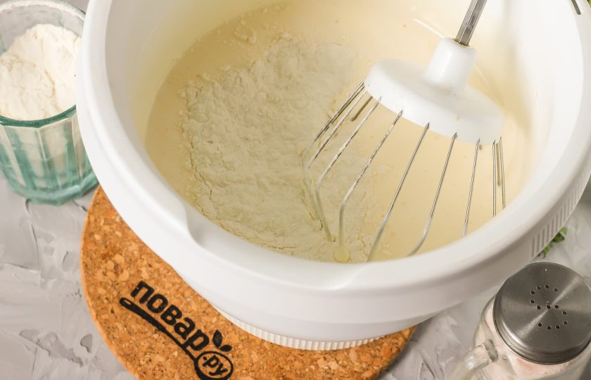 1. Этап. Бисквит на горячем молоке: Всыпьте в яичную массу пшеничную муку с разрыхлителем и аккуратно перемешайте на малых оборотах техники, создавая бисквитное тесто.