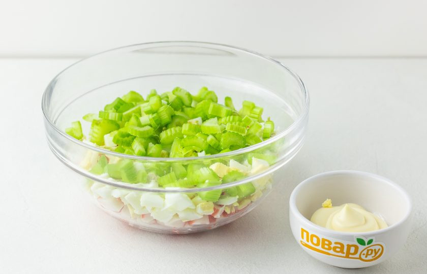 1. Этап. Крабовый салат с сельдереем: Затем добавьте рубленные кубиком яйца и нарезанные кусочками стебли сельдерея.