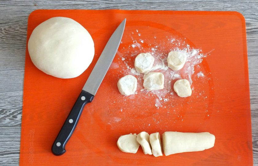 1. Этап. Пельмени из судака: Достаньте тесто из холодильника. Отрежьте небольшой кусочек и скатайте жгут. Жгут разрежьте на кусочки толщиной 1 см.