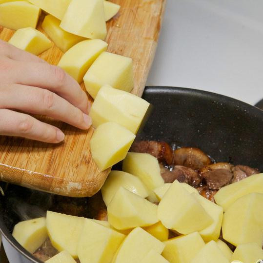 1. Этап. Тушенная утка с баклажанами и картофелем: Почистите и порежьте картофель, добавьте его к утке и готовьте всё вместе, изредка помешивая.