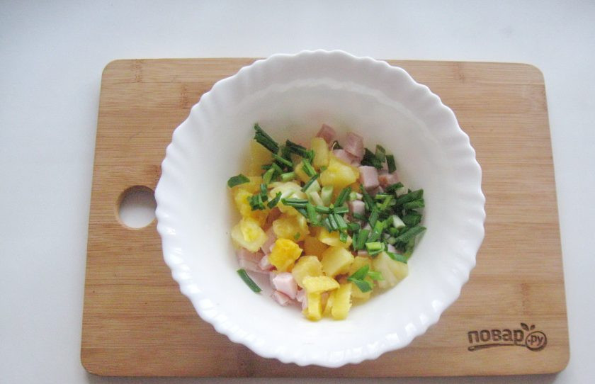 1. Этап. Салат с ананасом на Новый год: Зеленый лук мелко нарежьте и выложите в салатник.