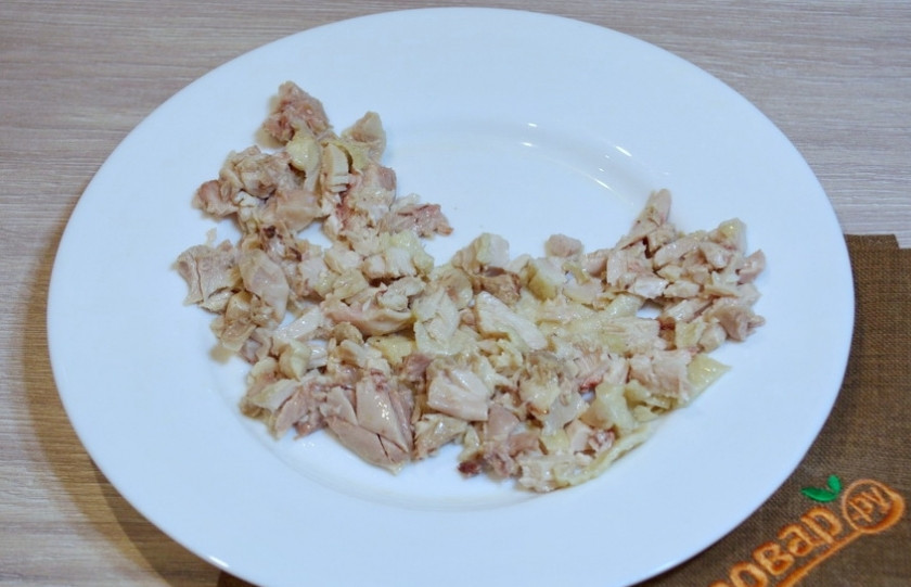1. Этап. Салат Петух на Новый год: Для приготовления салата нам необходимо отварить куриное мясо. Затем мясо остудить и нарезать меленько. Уложите нарезанное мясо на плоское блюдо в форме полумесяца.