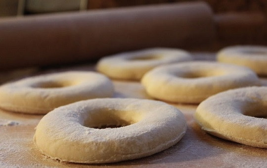 1. Этап. Пончики во фритюре: 4. Раскатайте тесто, вырежьте пончики, снова накройте полотенцем. Оставьте их подходить на столе еще минут на 20.