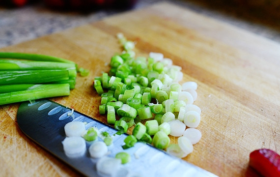 1. Этап. Салат с клубникой и курицей: Мелко нарежьте зелёный лук.