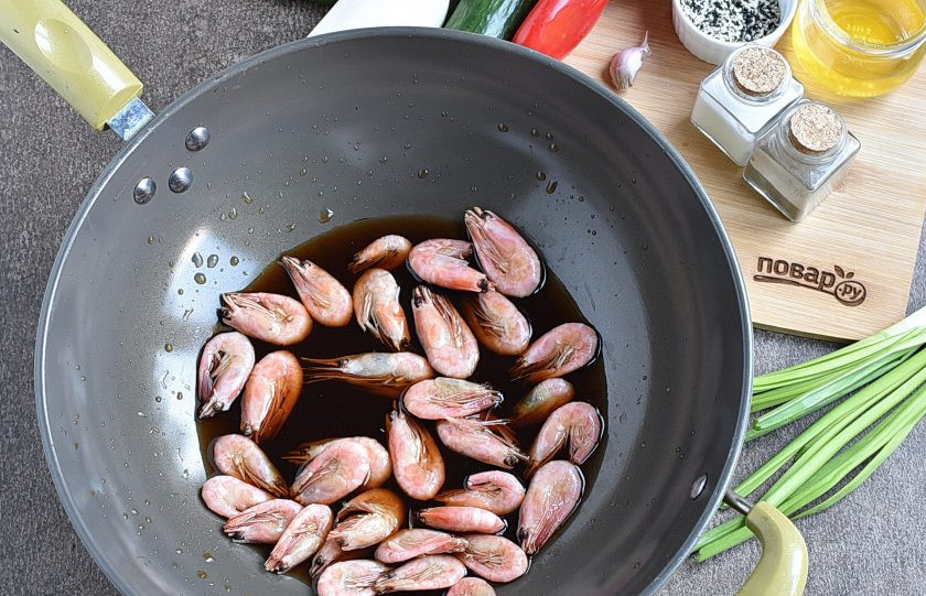 1. Этап. Китайский салат с креветками: Варено-мороженые креветки, не размораживая, залейте соевым соусом, добавьте рисовый уксус и мирин. Быстро доведите до кипения и дайте остыть в маринаде.