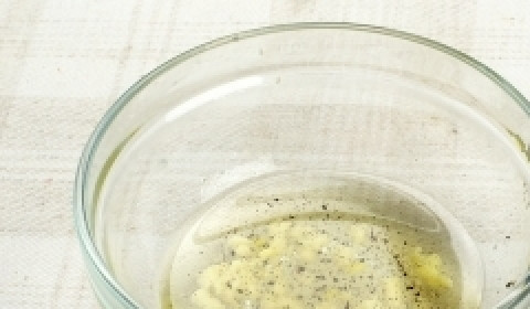 1. Этап. Салат из запеченных перцев: Пока ингредиенты будут готовиться в духовке, сделайте заправку. Измельчённый чеснок соедините с 3 ложками масла, молотым перцем и солью. Хорошо перемешайте.