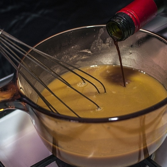 1. Этап. Винный соус: Добавьте вино и вновь смешайте все венчиком.