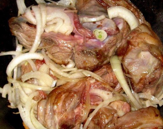 1. Этап. Шурпа из свиных ребрышек: Шурпу лучше всего готовить в казане. Разогреваем в нем растительное масло и обжариваем ребрышки до золотистой корочки. Затем добавляем к мясу очищенный и нарезанный лук. Перемешиваем и обжариваем 3-4 минуты.