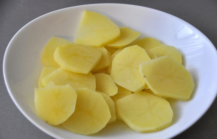 1. Этап. Пирог с зубаткой: Почистите и порежьте картофель пластинками.